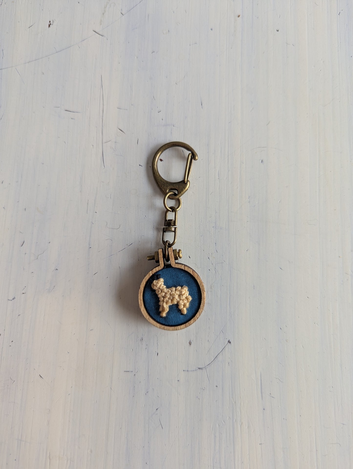 Keychain with embroidered alpaca design on a blue background