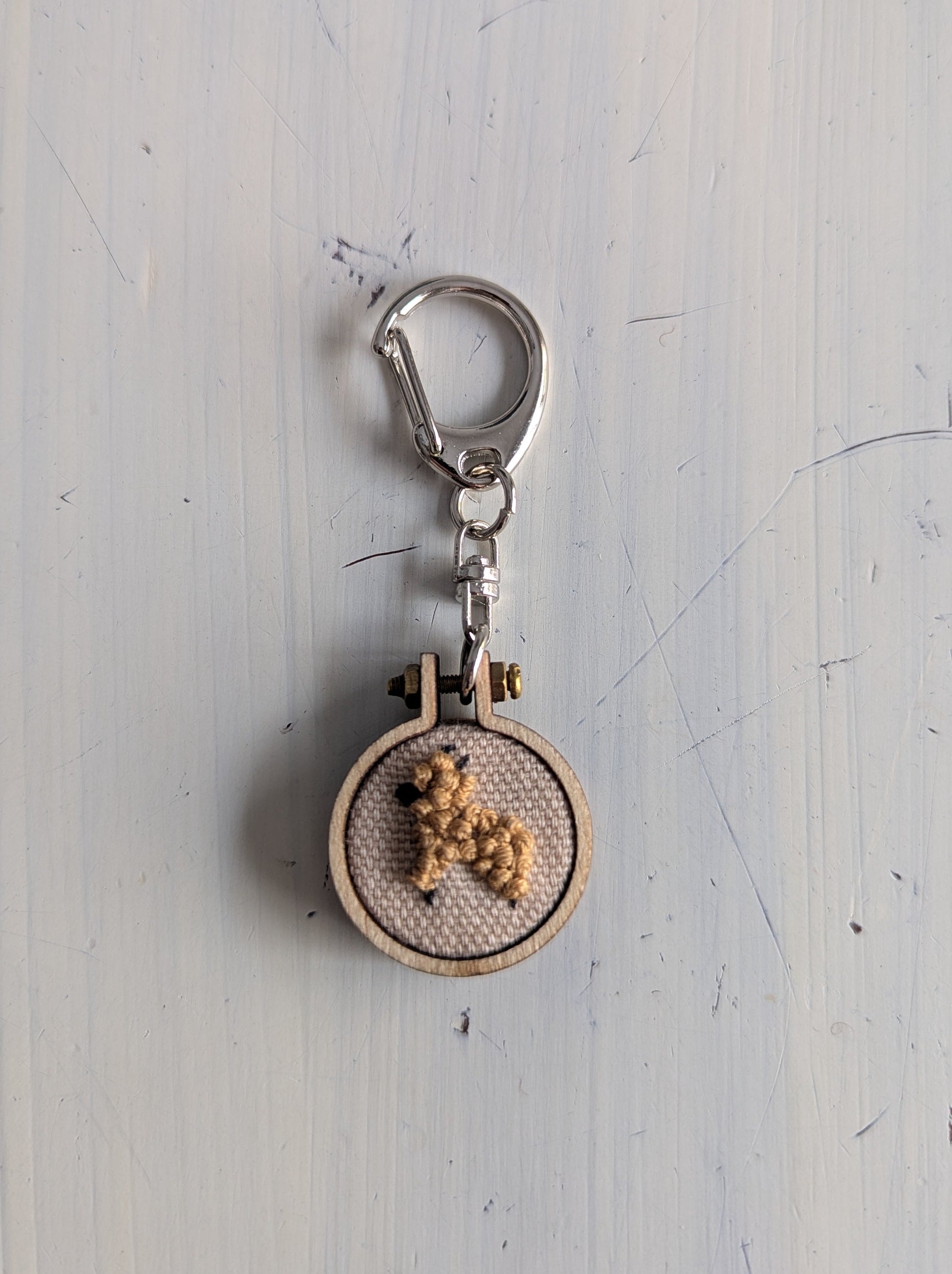 Keychain with embroidered design on a light gray background