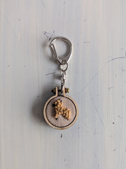 Keychain with embroidered design on a light gray background
