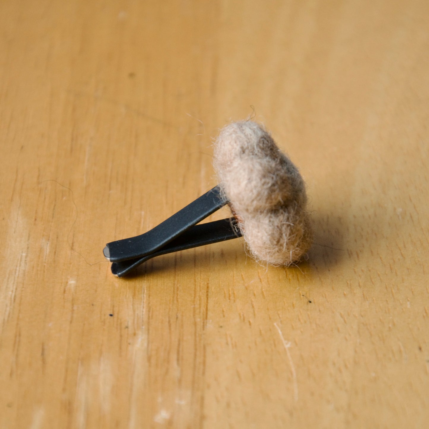 Needle felt air freshener in the shape of a beige flower