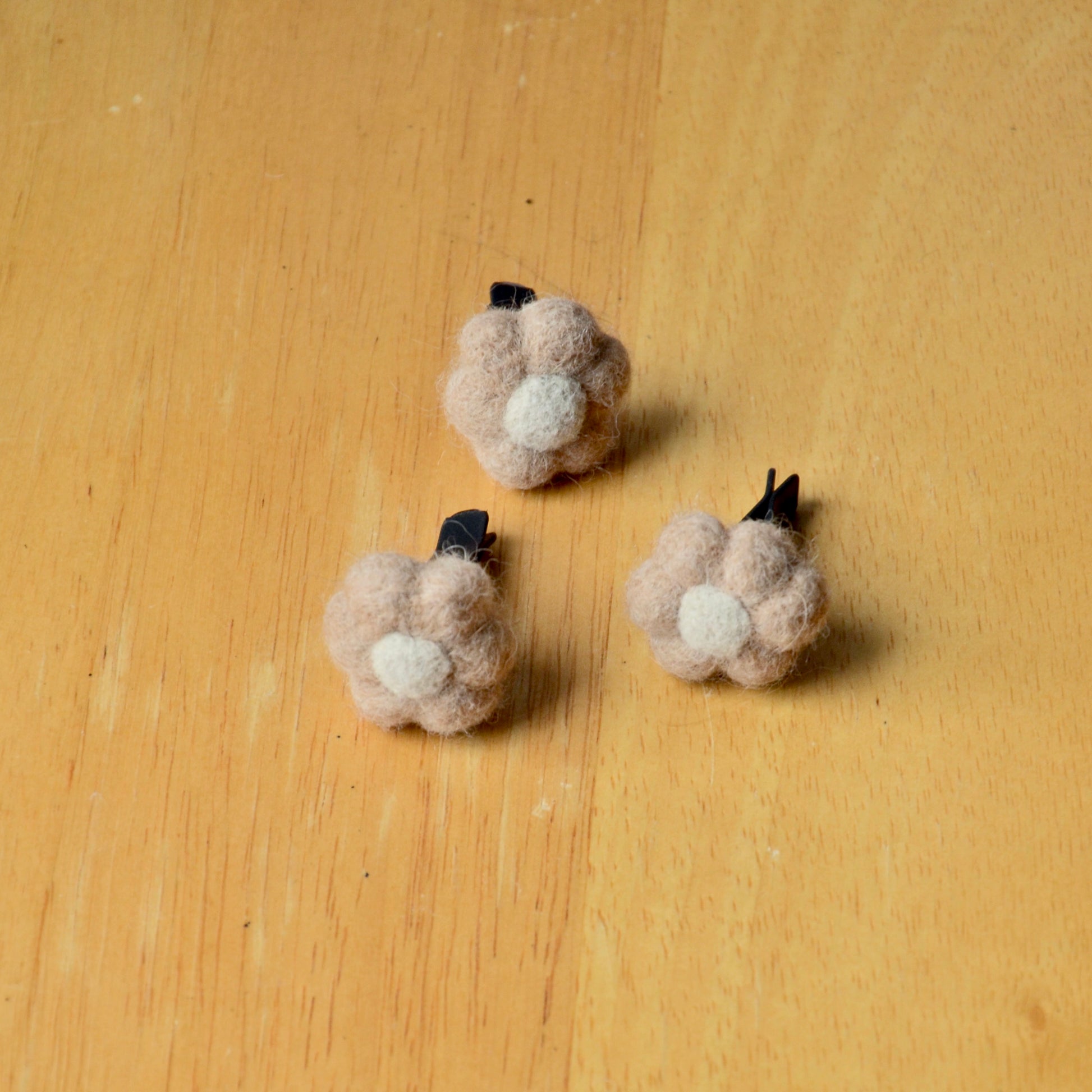 Needle felt air freshener in the shape of a beige flower