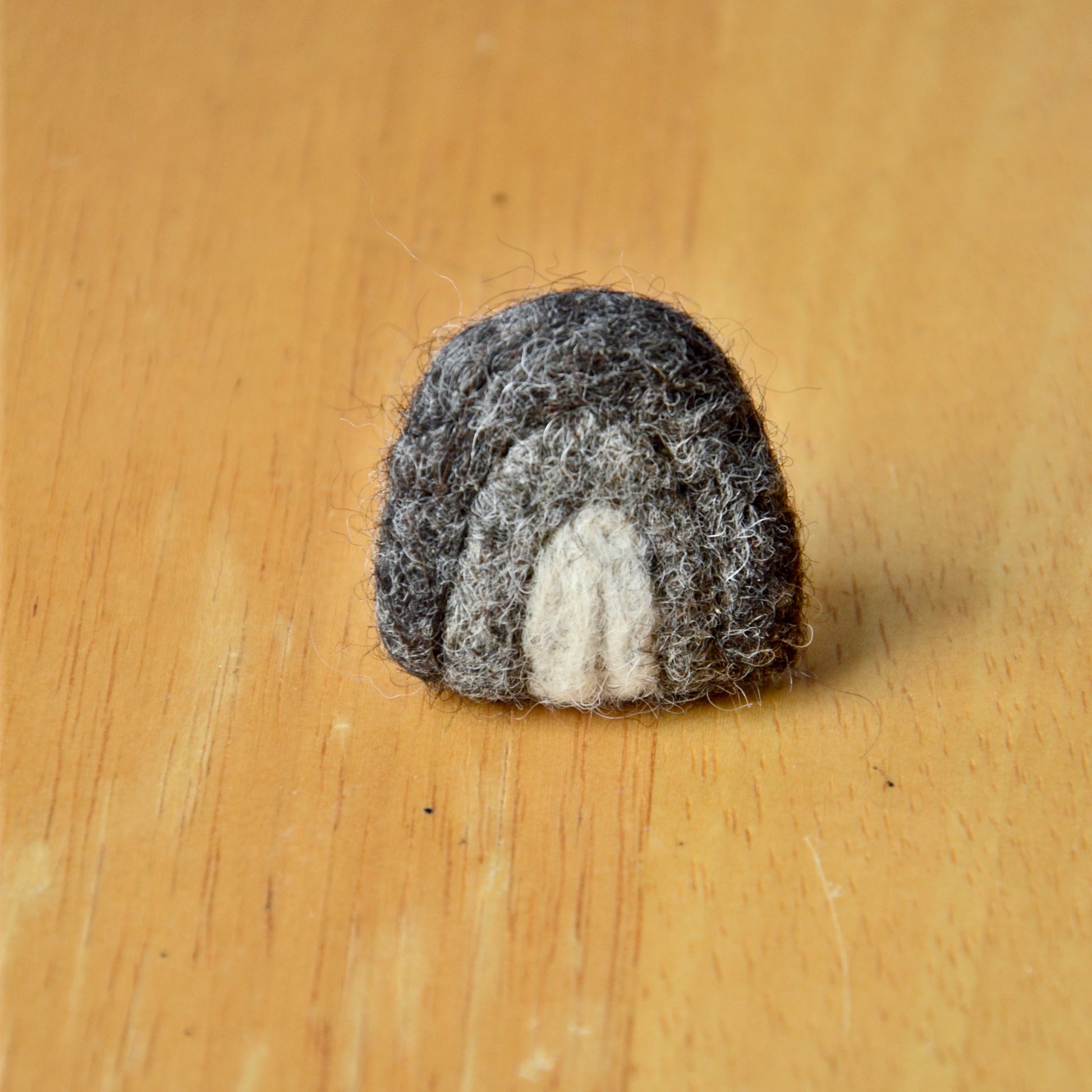 Needle felt air freshener in the shape of a gray rainbow