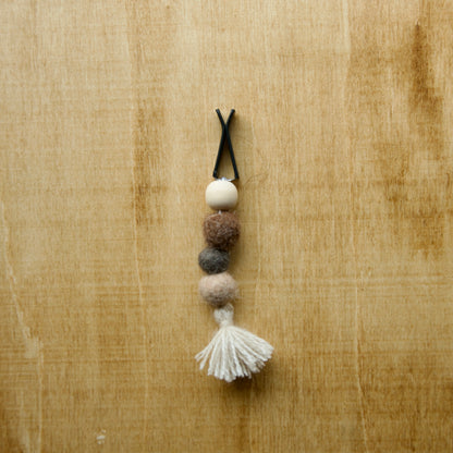 Felted air freshener tassle over a wooden background