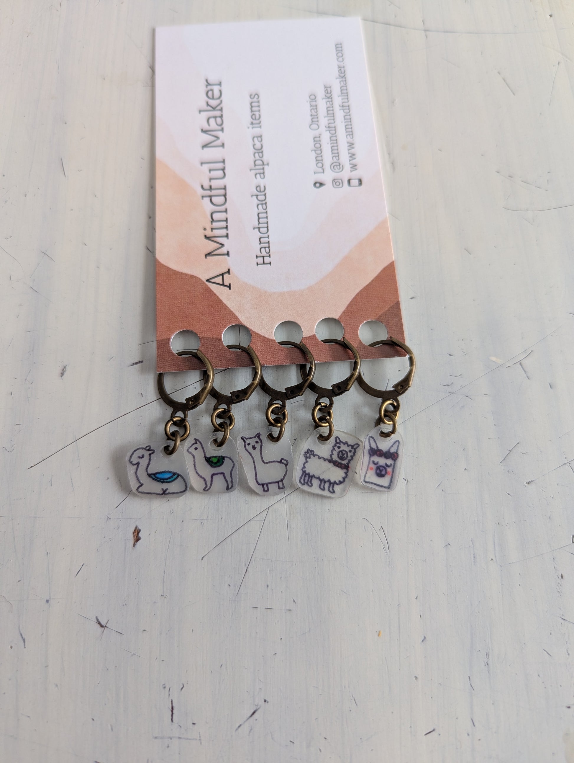 Set of keychains with llama designs on a 'A Mindful Maker' branded card.