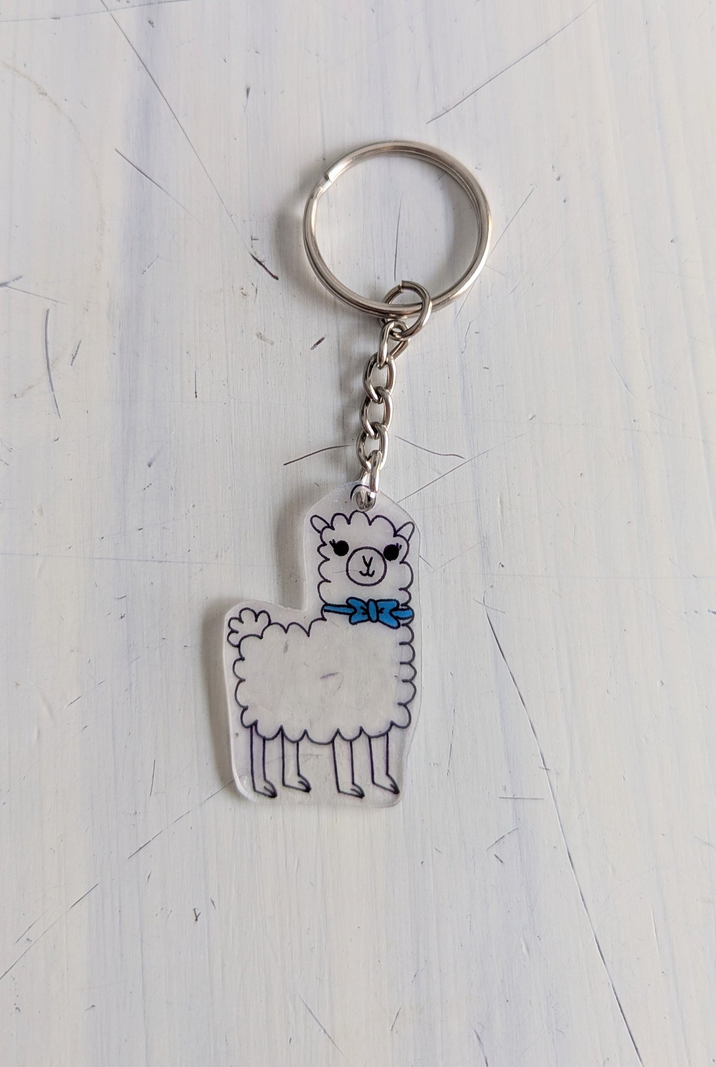 Keychain with a llama design on a light gray surface