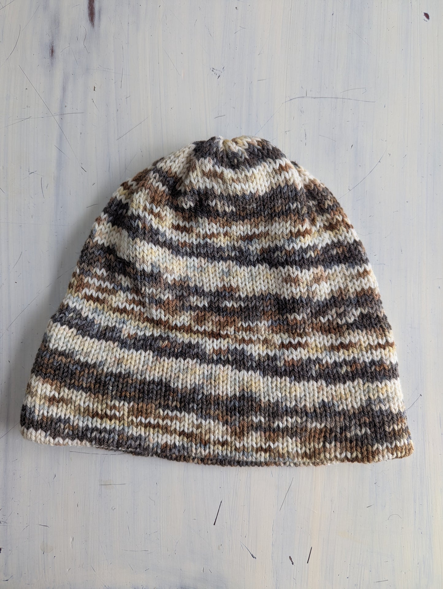 Striped knit beanie on a light wooden surface