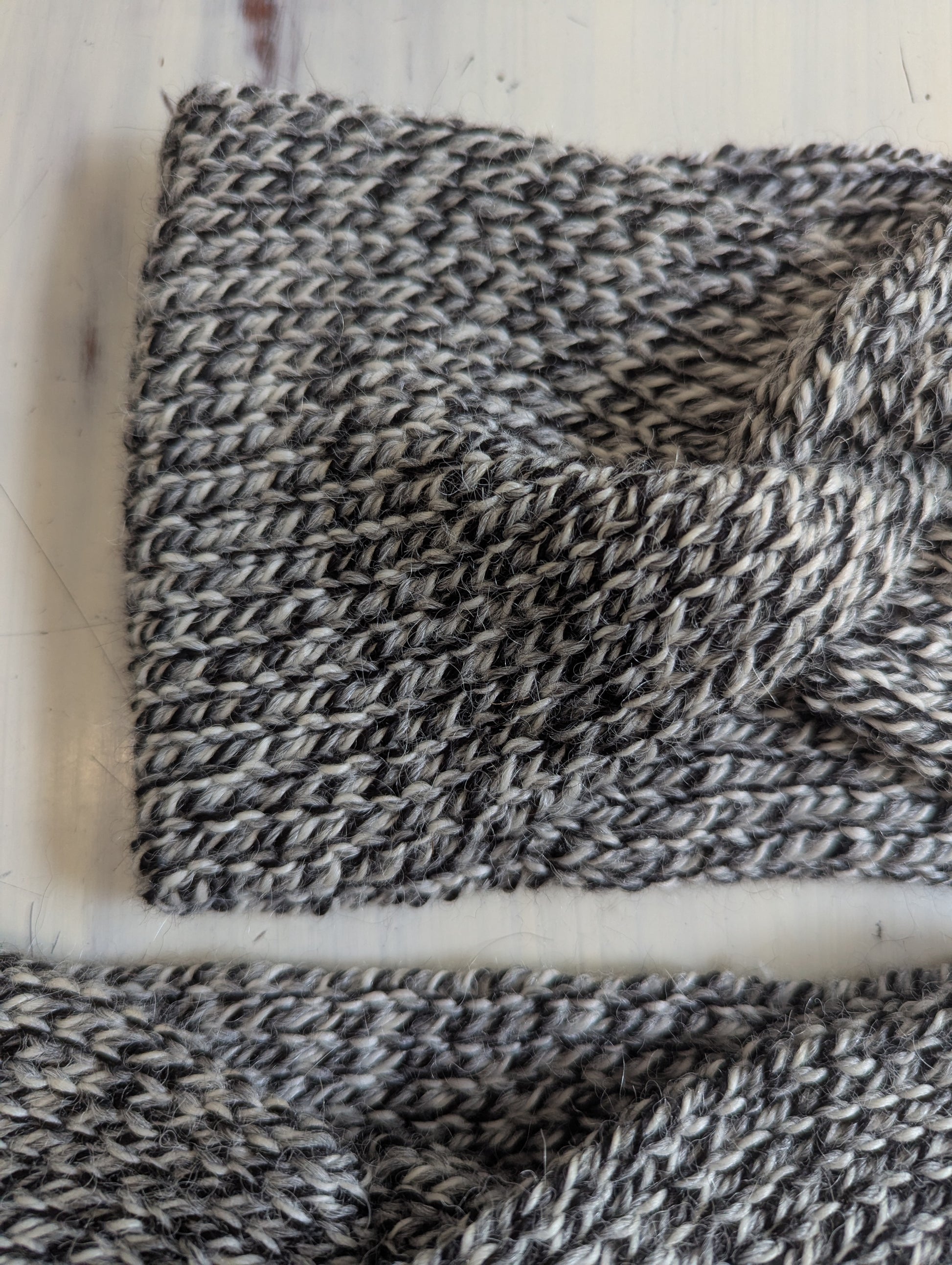 Close-up of a knitted fabric with a variegated pattern on a white background
