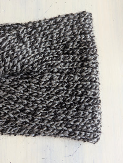 Close-up of a knitted fabric with a textured pattern on a white background