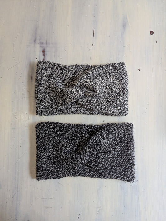 Two knitted headbands on a light wooden surface