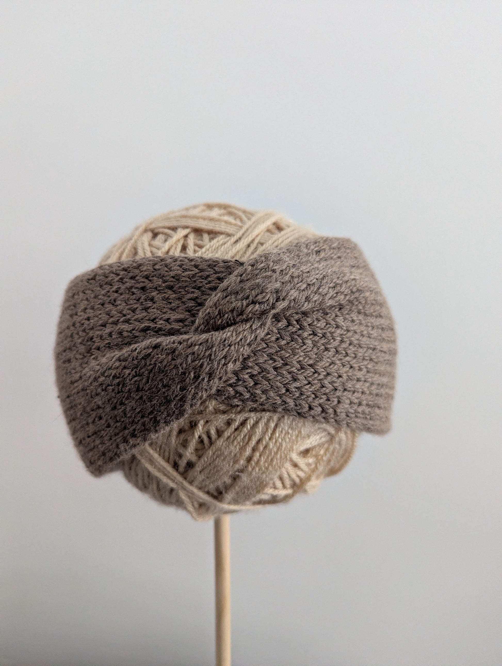 Knitted headband with yarn on a gray background