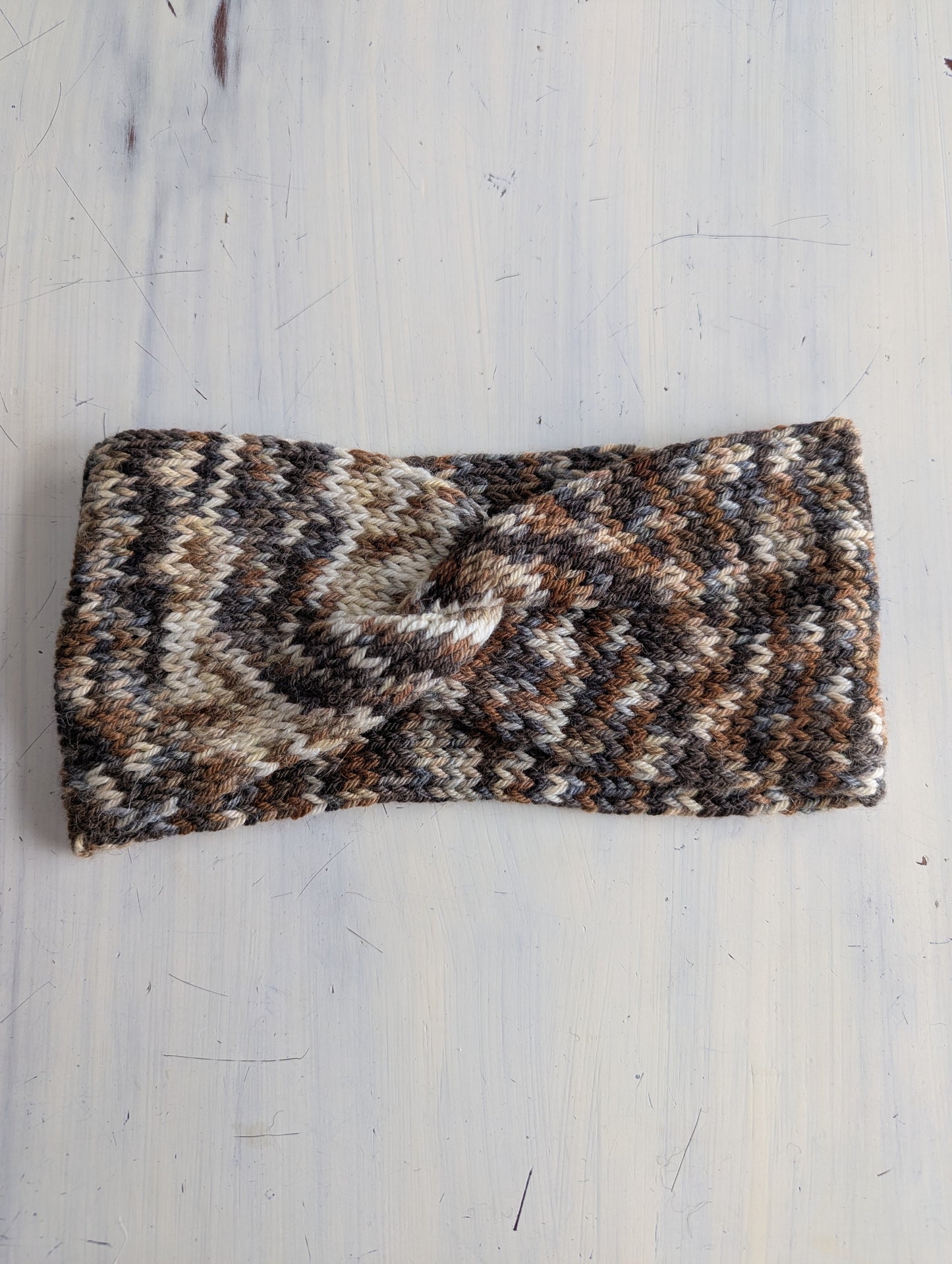 Knitted headband with a pattern on a light wooden surface