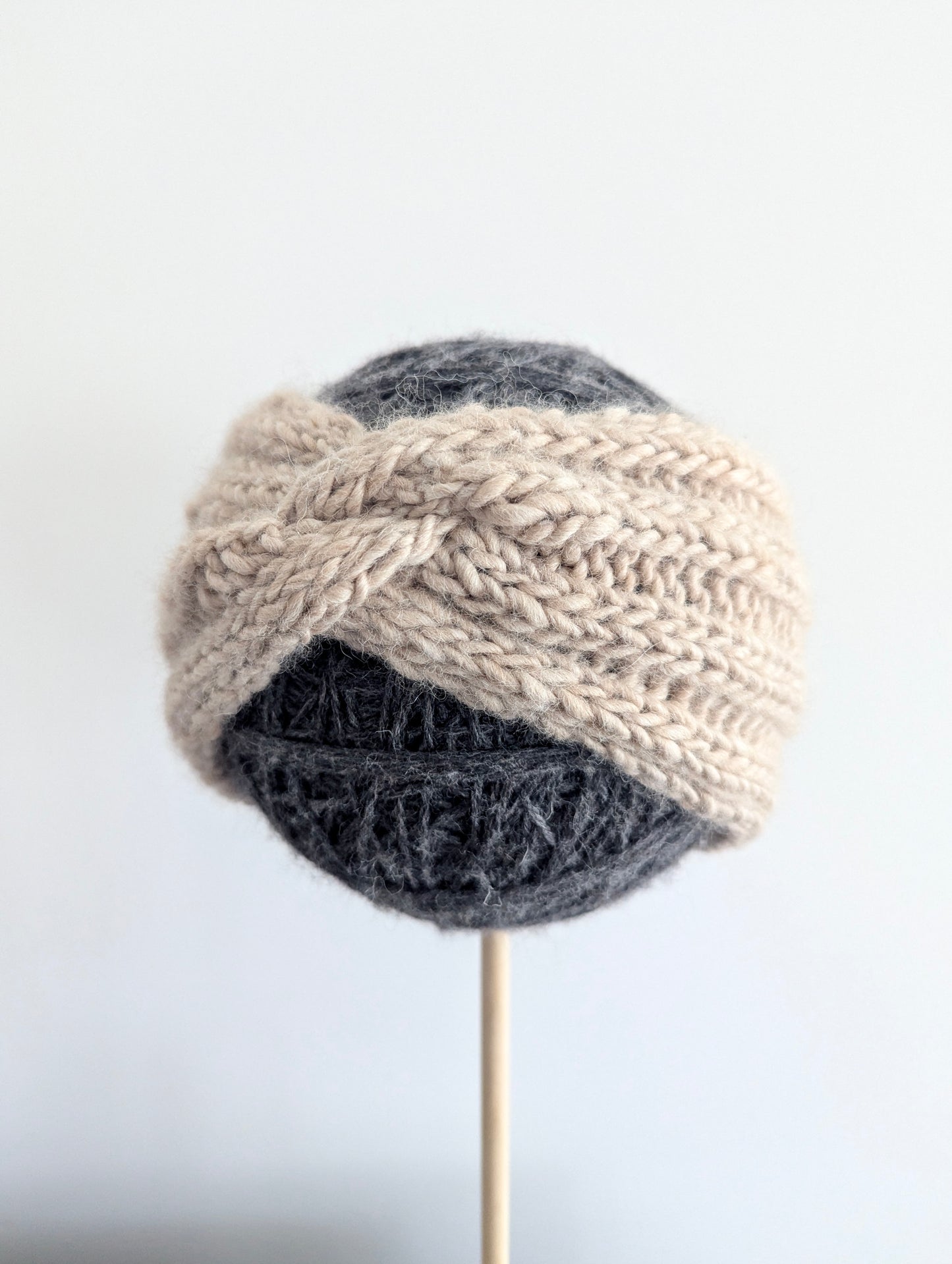 Knitted headband with a braided design on a white background