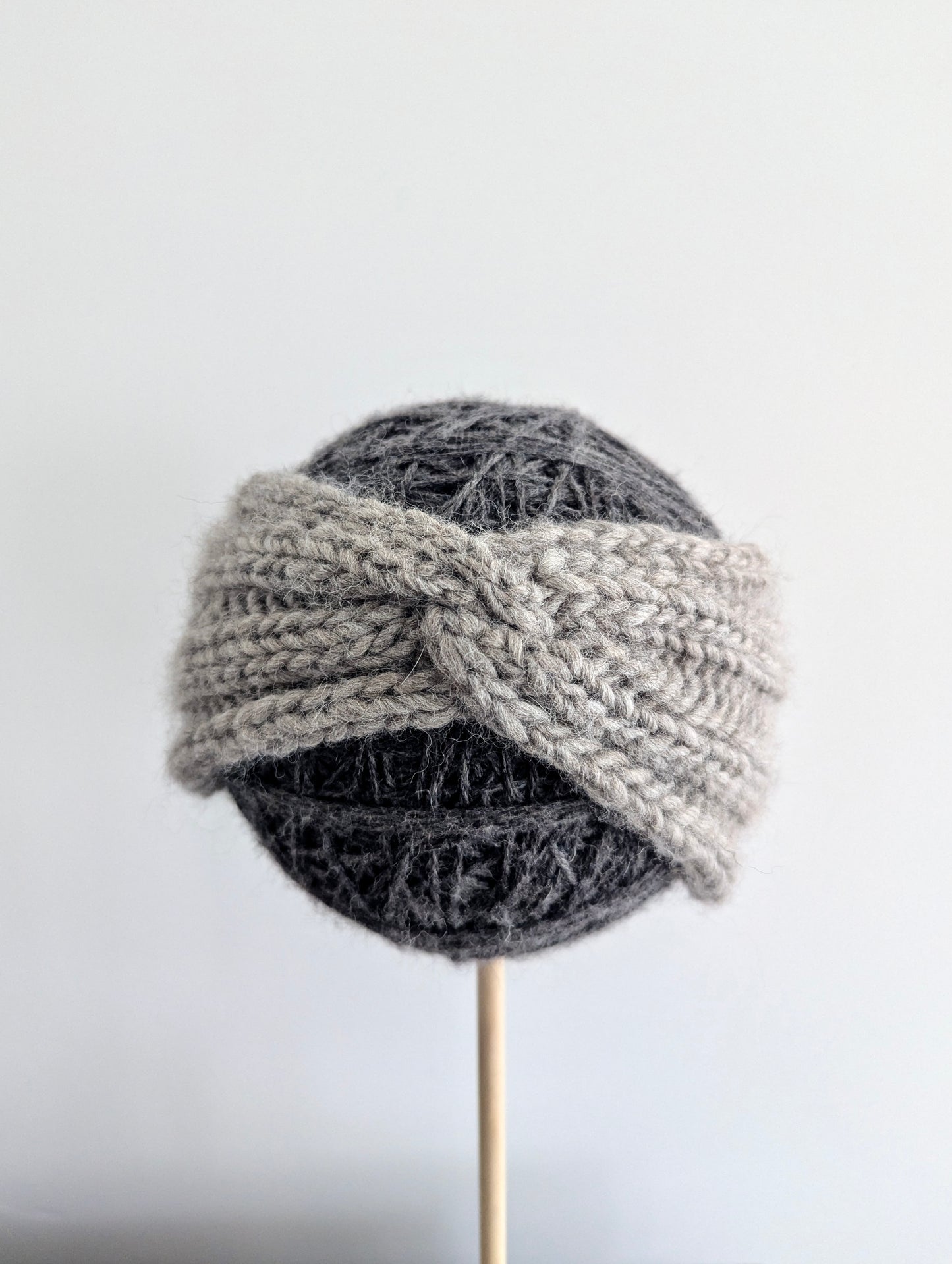 Knitted gray hat on a mannequin head against a white background