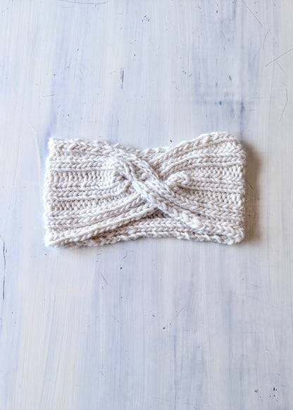 Knitted headband on a light wooden surface