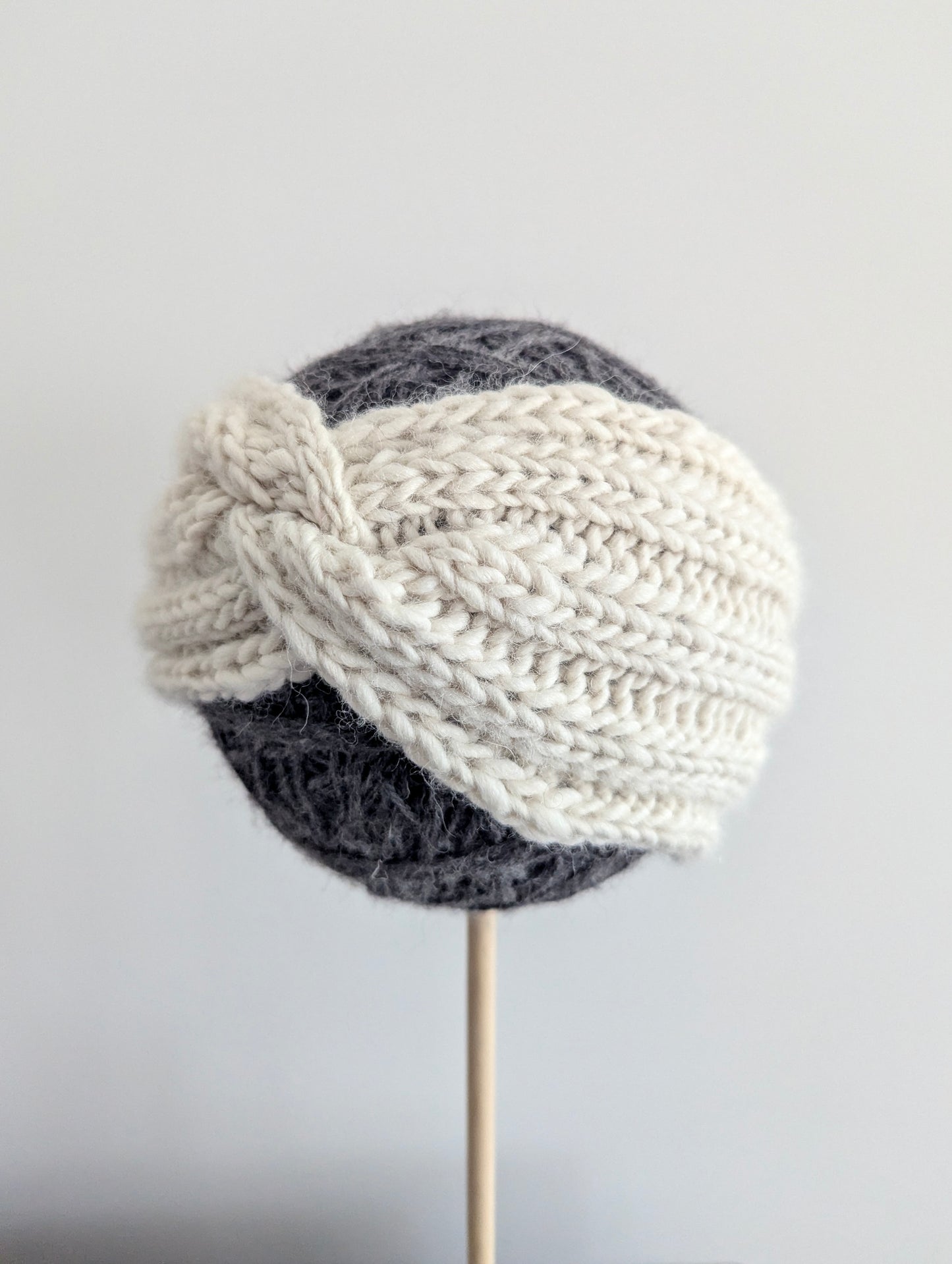 Knitted turban hat with two-tone design on a gray background