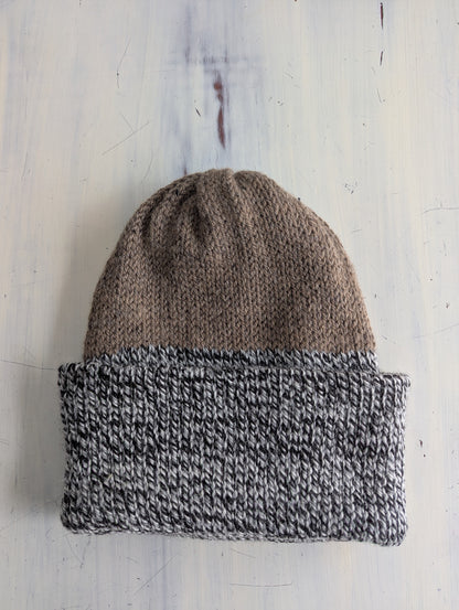 Knitted beanie with two-tone design on a wooden surface