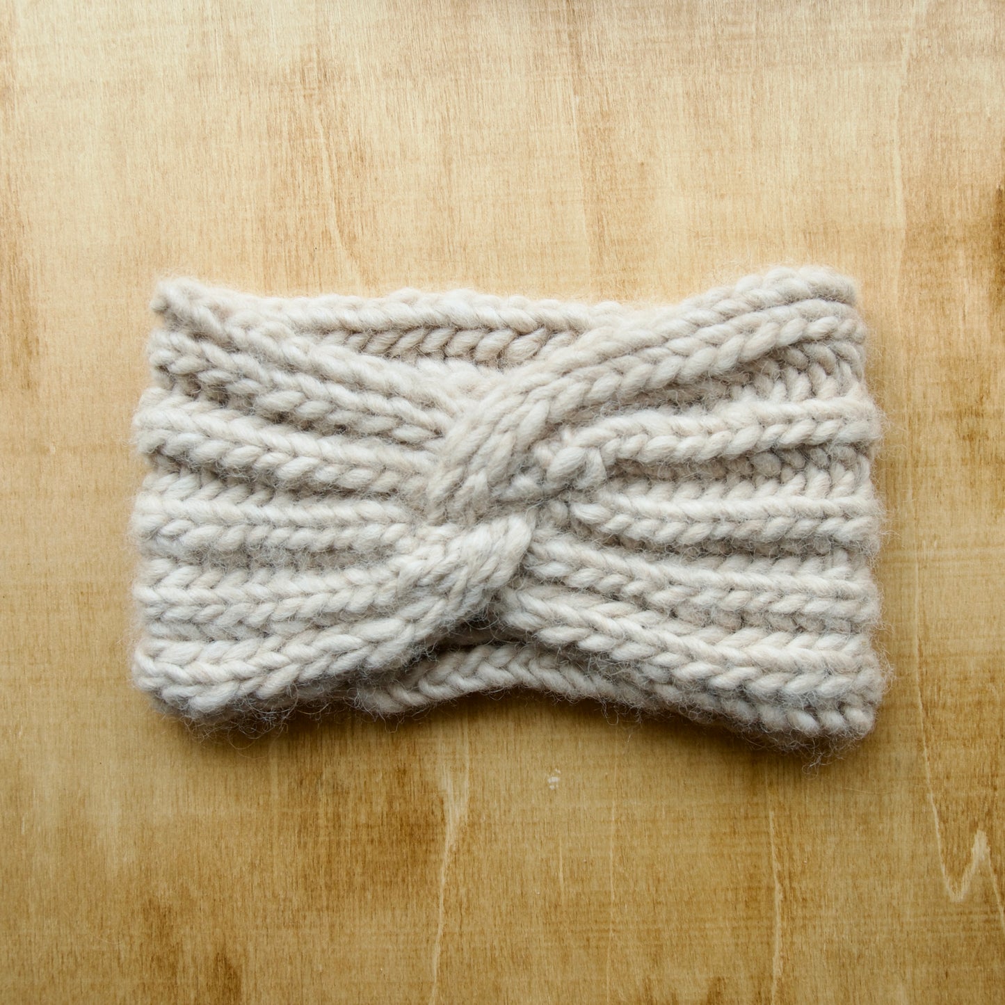 White knit headband with ribbing over a wood background
