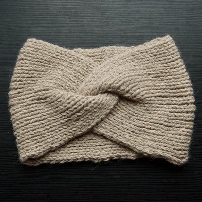 Beige headband flat lay on a dark surface