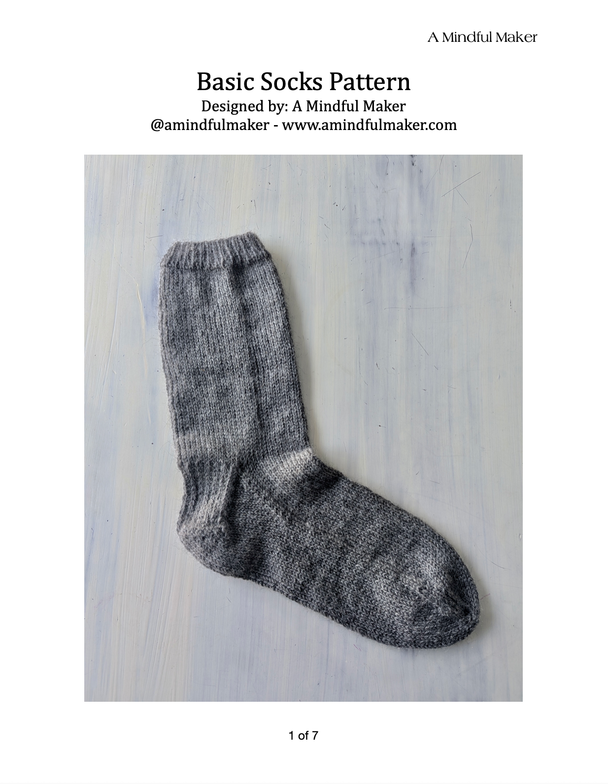 Knitted sock on a wooden surface with 'A Mindful Maker' branding.