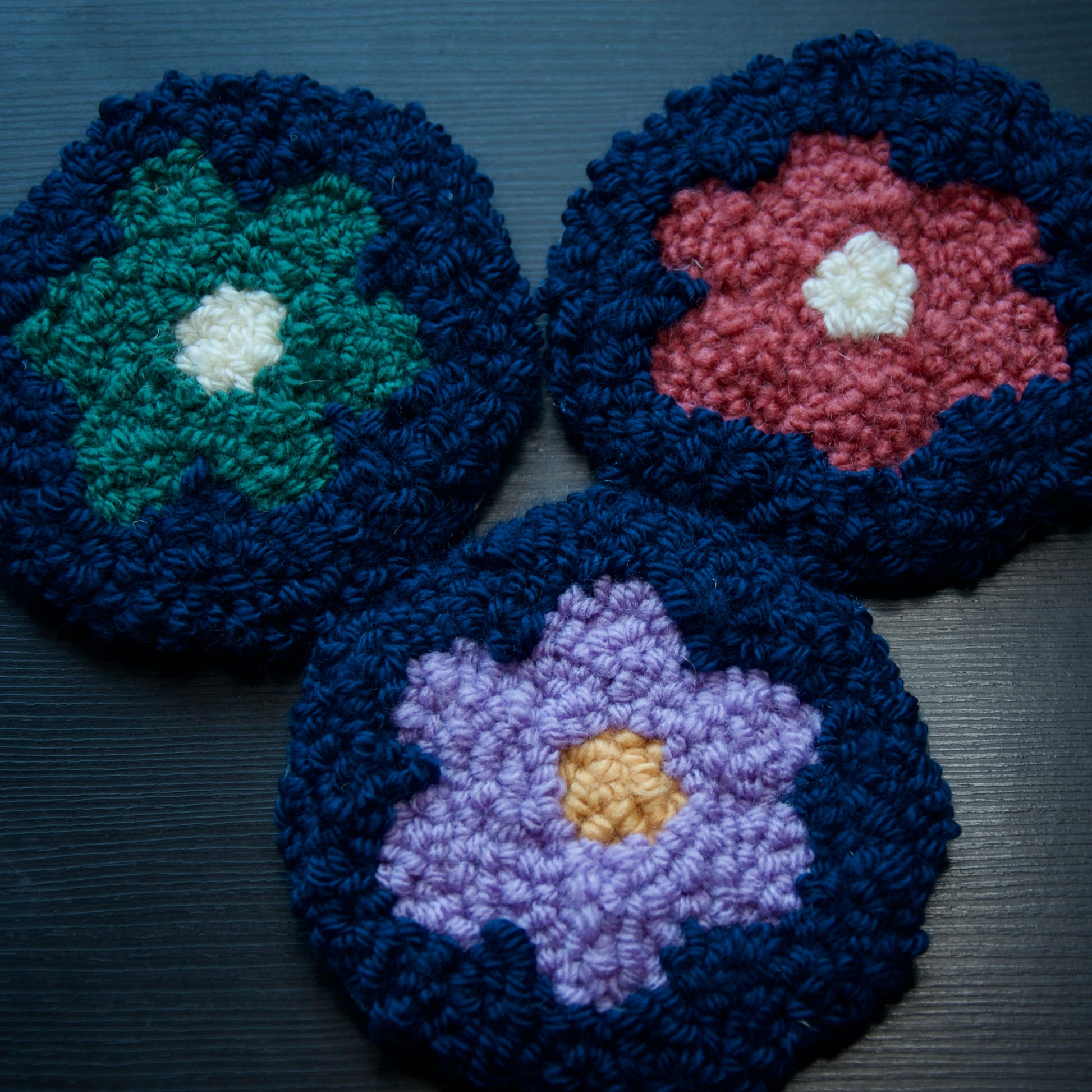 A set of 3 round coasters with floral patterns in various colors.