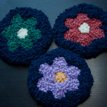 A set of 3 round coasters with floral patterns in various colors.