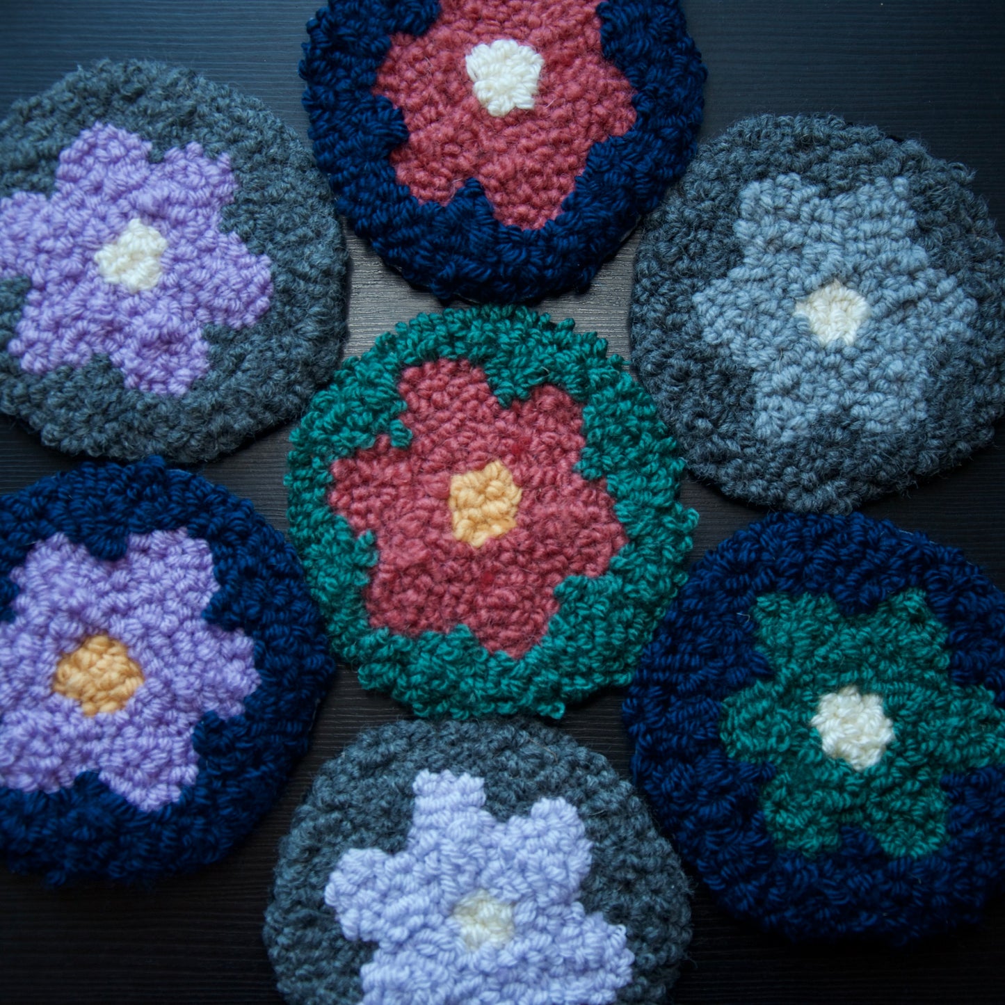A set of round coasters with floral patterns in various colors.