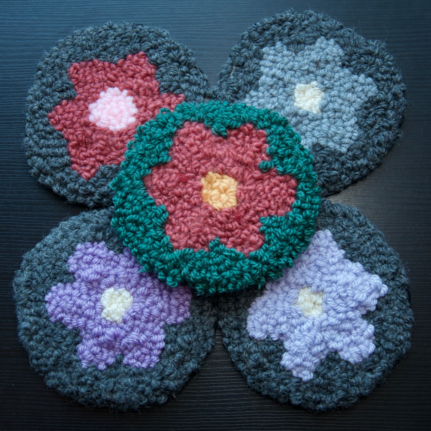 A set of 5 round coasters with floral patterns in various colors.