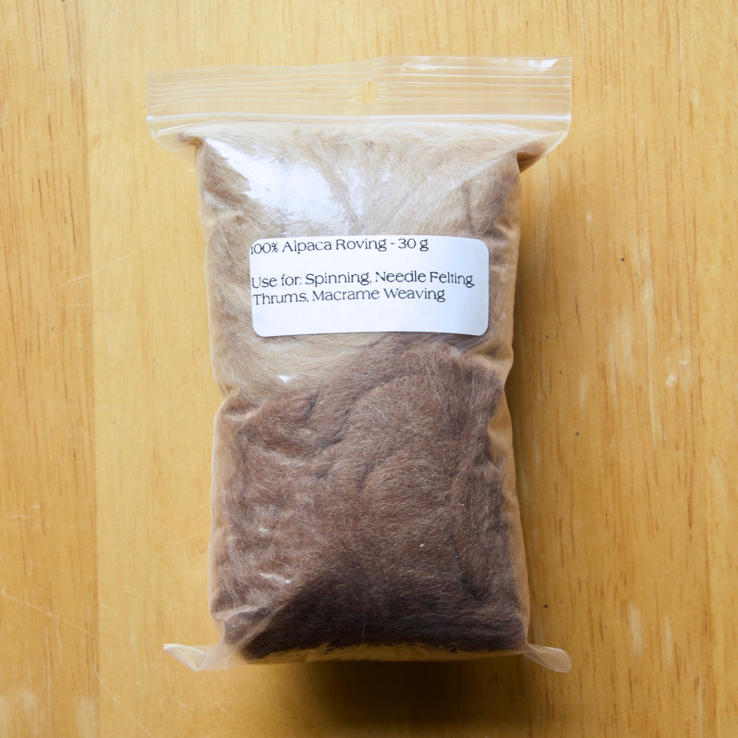 Brown alpaca roving in a clear bag
