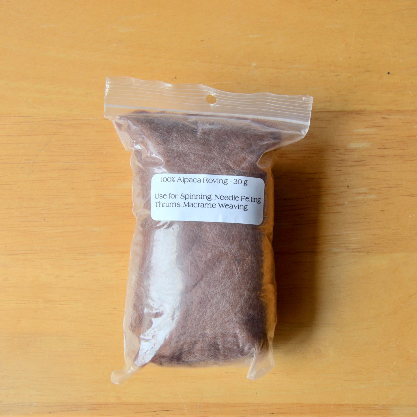 Brown alpaca roving in a clear bag