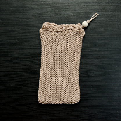 A knit soap saver pouch over a dark surface