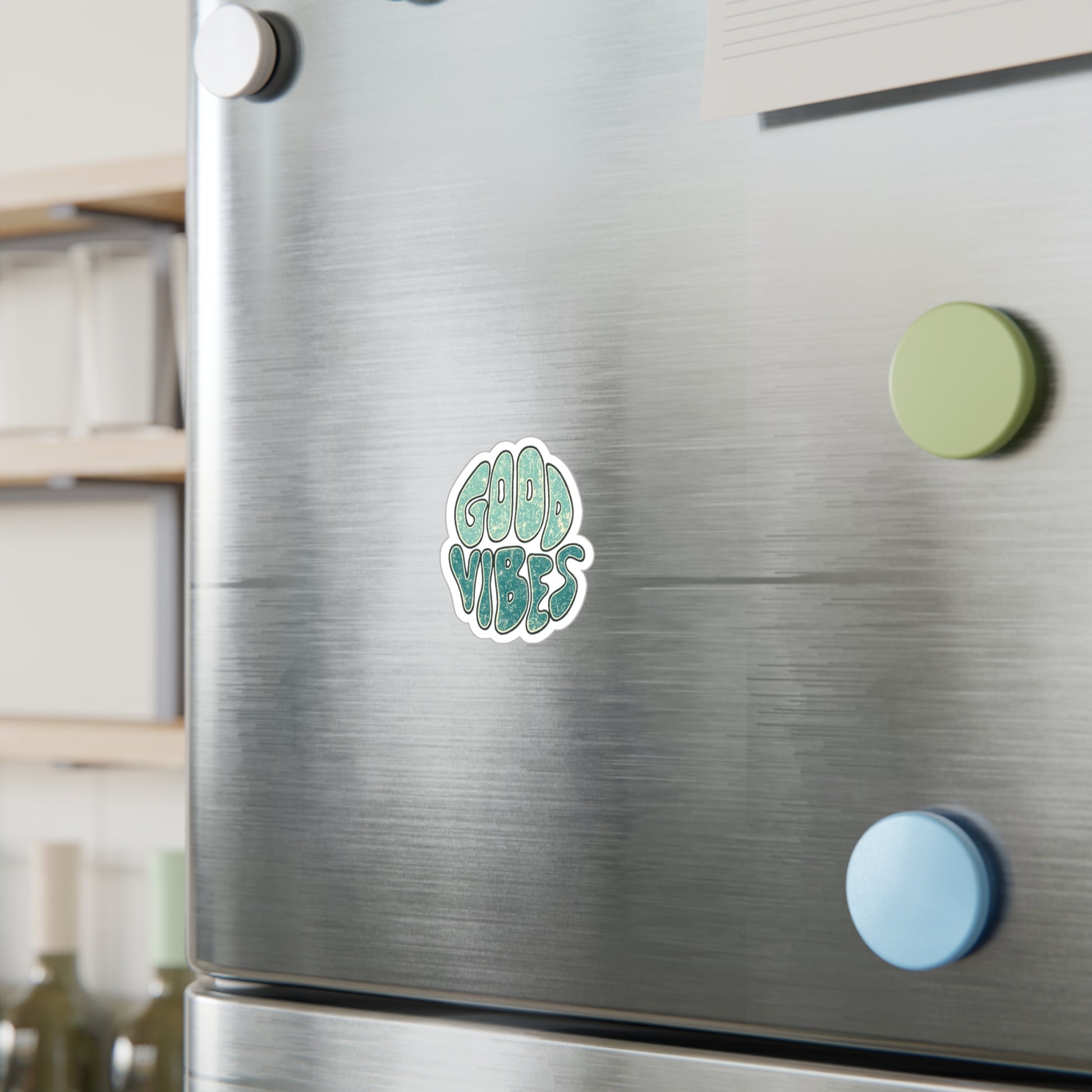 Sticker with 'Good Vibes' text on a refrigerator door